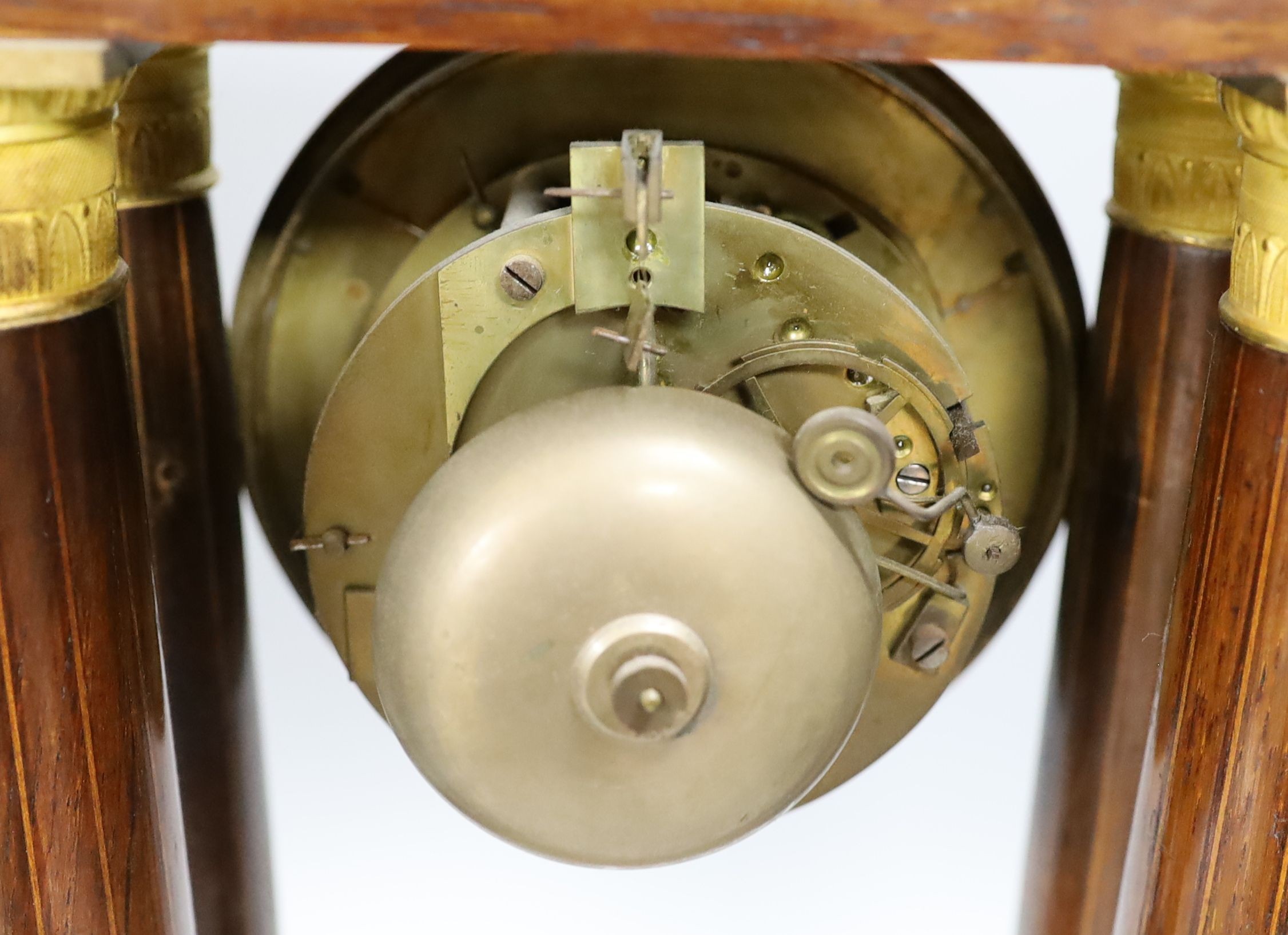 A French rosewood and marquetry portico clock, with pendulum, no key, 44 cms high.